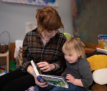 Woman reading a book to a child.