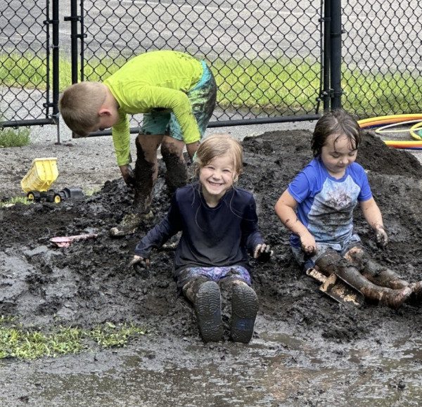 Messy children having fun playing in the mud